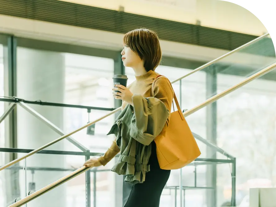 飲み物を持った女性が階段を降りている画像