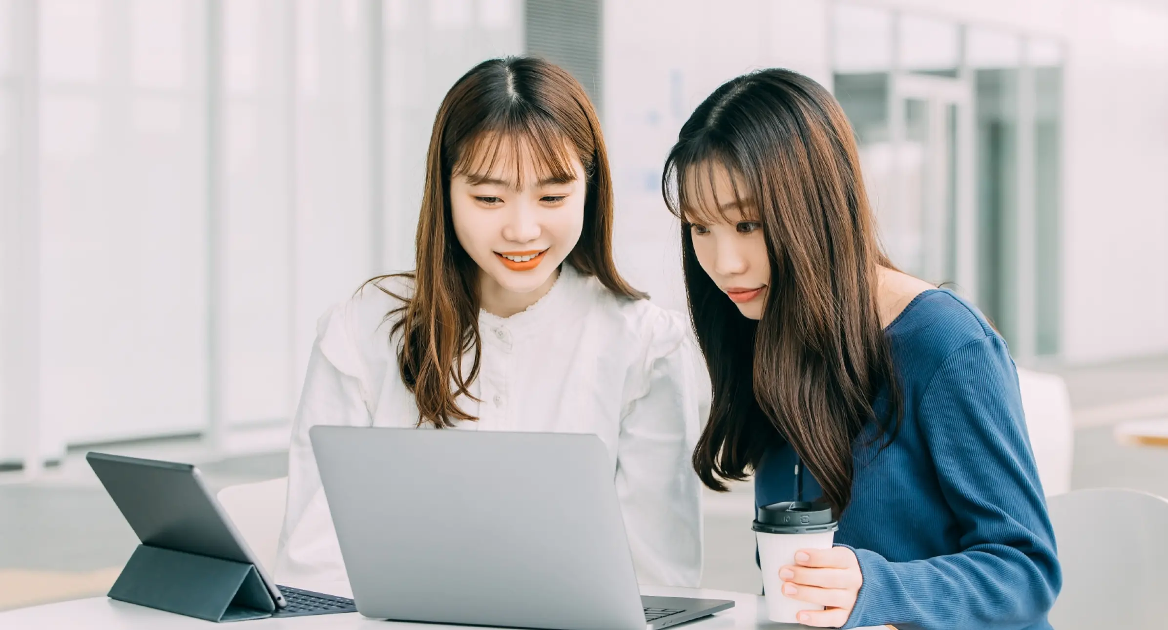 二人の女性がパソコンで作業している画像